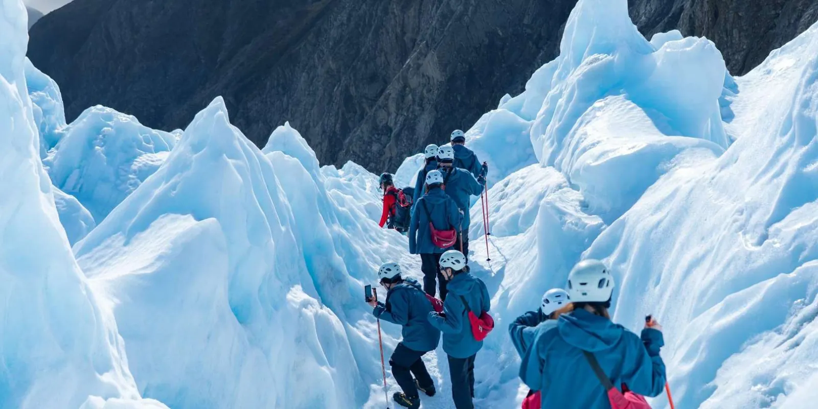 Group walking between sculpted ice formations
