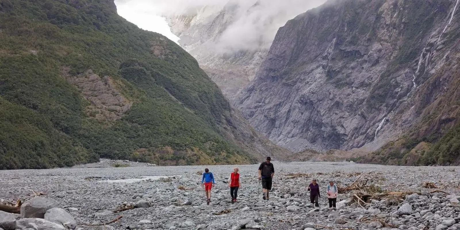 Walkers in a broad rocky glacier valley