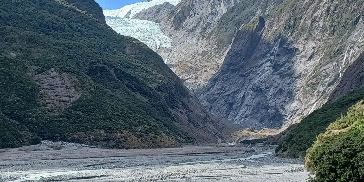 Glacier valley framed by green hillsides