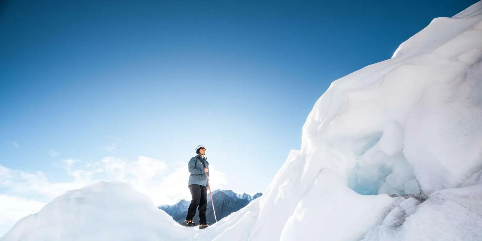 Hiker on a broad snowy glacier ridge