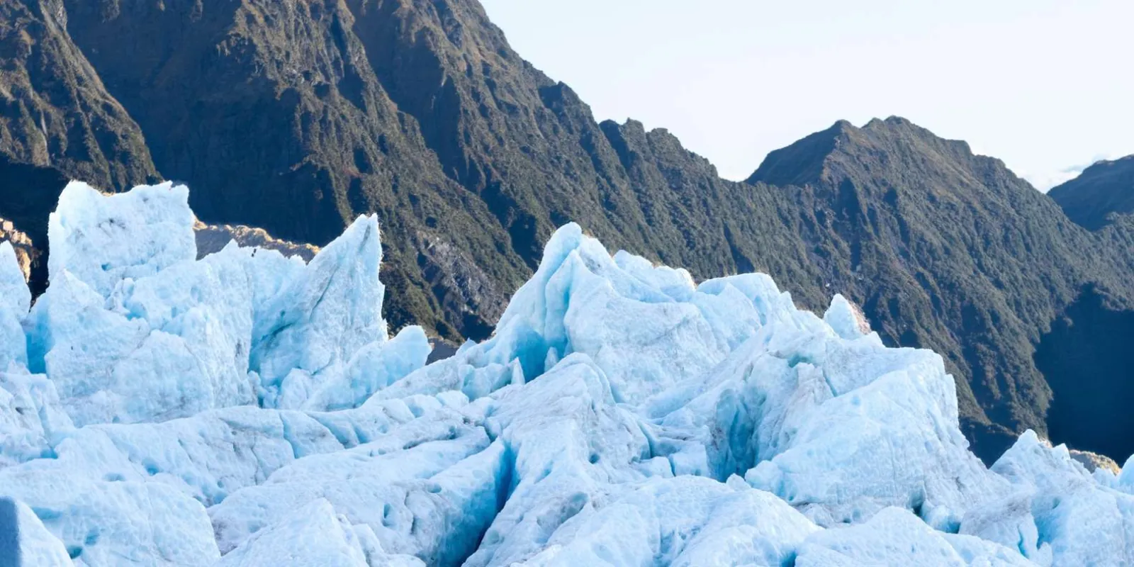 Glacier ice formations beneath a rocky ridge