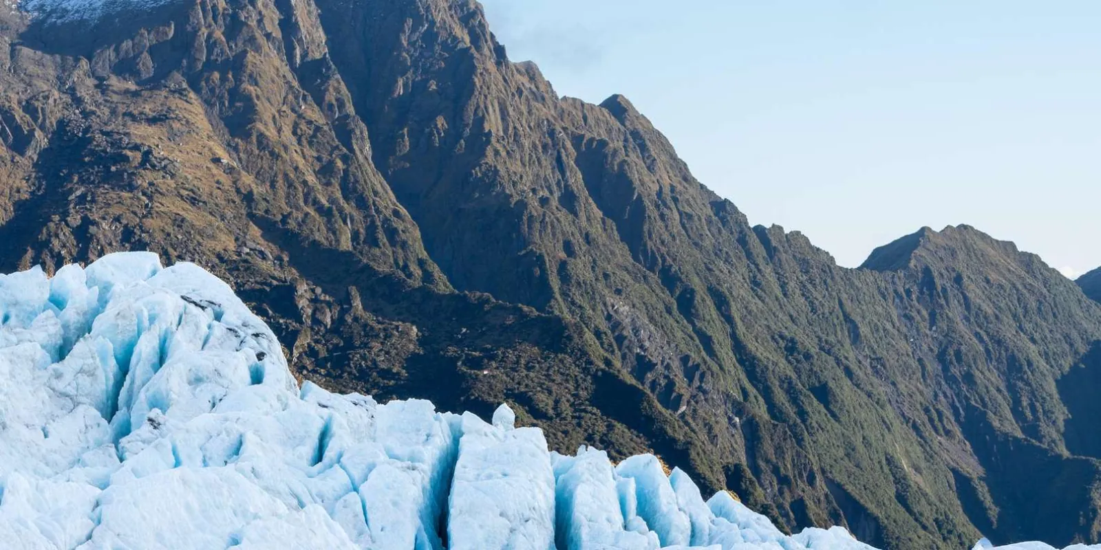 Blue glacier ice with a mountain backdrop
