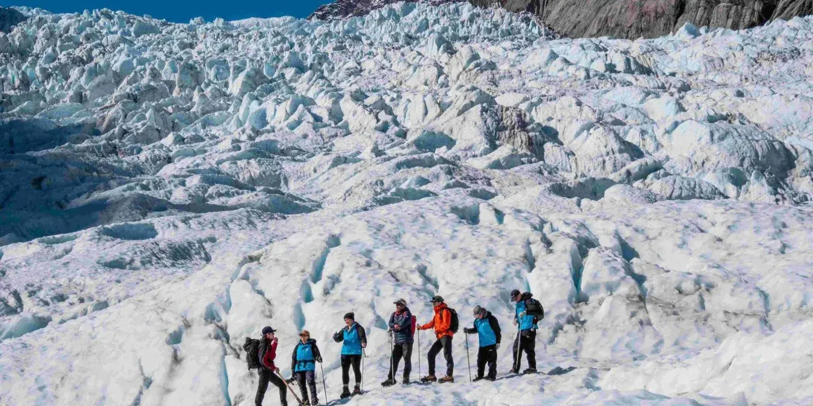 Small group walking across glacier terrain